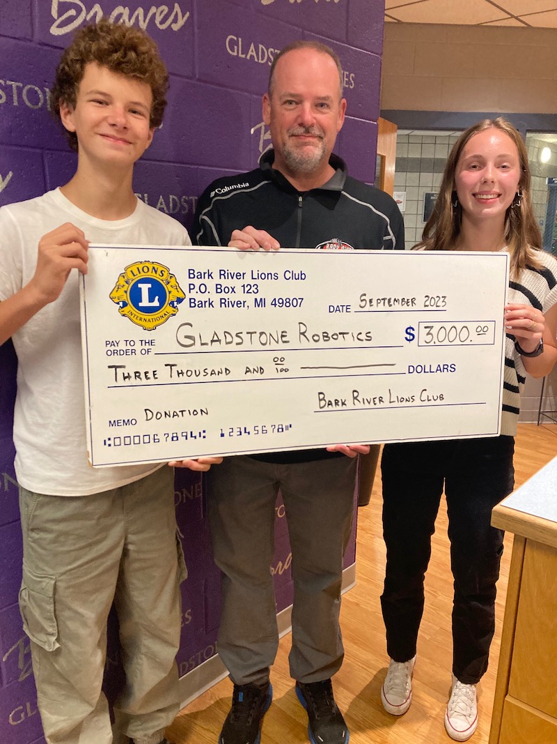 Accepting the check for the Gladstone Robotics Program are students Brant Veeser and Peyton Rorh with the check being presented by Scott Kwarciany, 1VDG and Chairman of Bark River International Raceway.